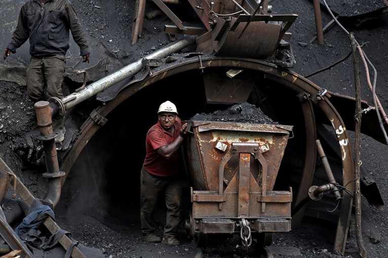 In this Monday, Aug. 18, 2014 photo, an Iranian coal miner pushes a metal cart loaded with coal at a mine near the city of Zirab 212 kilometers (132 miles) northeast of the capital Tehran, on a mountain in Mazandaran province, Iran. The miner move up to 100 tons of coal a day. (AP Photo/Ebrahim Noroozi)